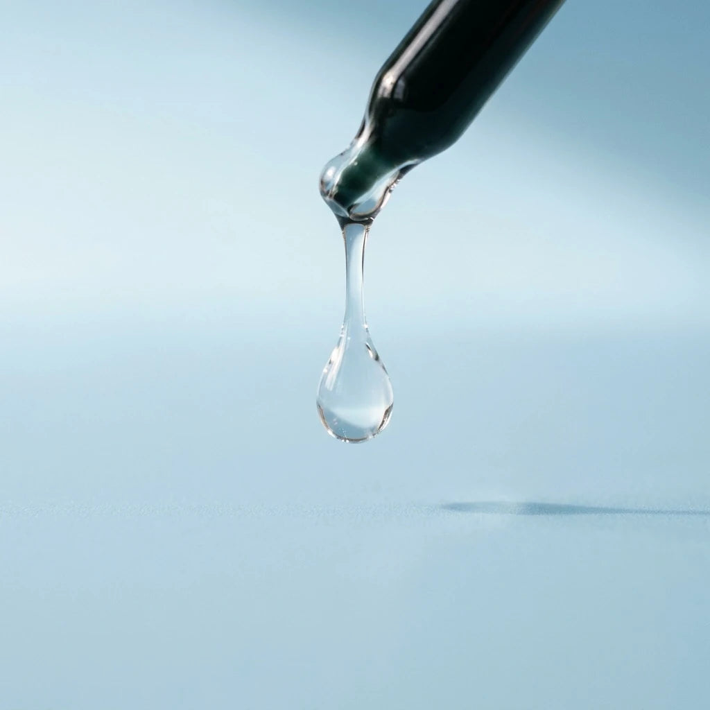A dropper releasing a clear droplet